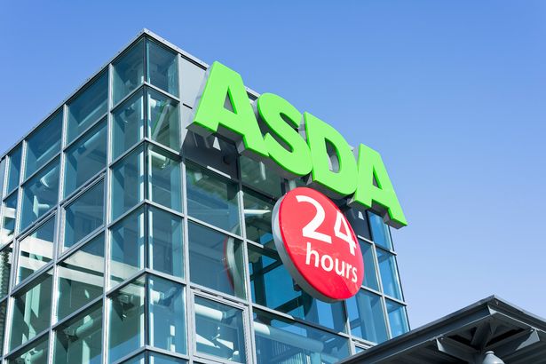 An entrance sign on the exterior of a large Asda supermarket