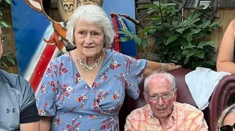 Family handout Doreen and her husband Gordon sitting for a photo at a family party