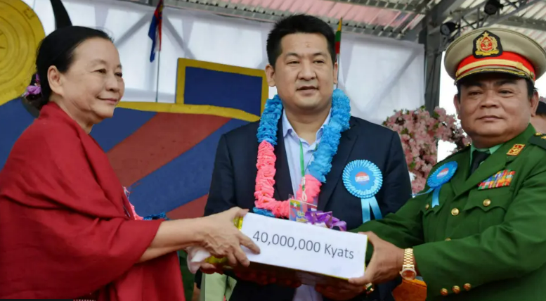 She Zhijiang and Saw Chit Tu, a Myanmar warlord, exchanging a donation.